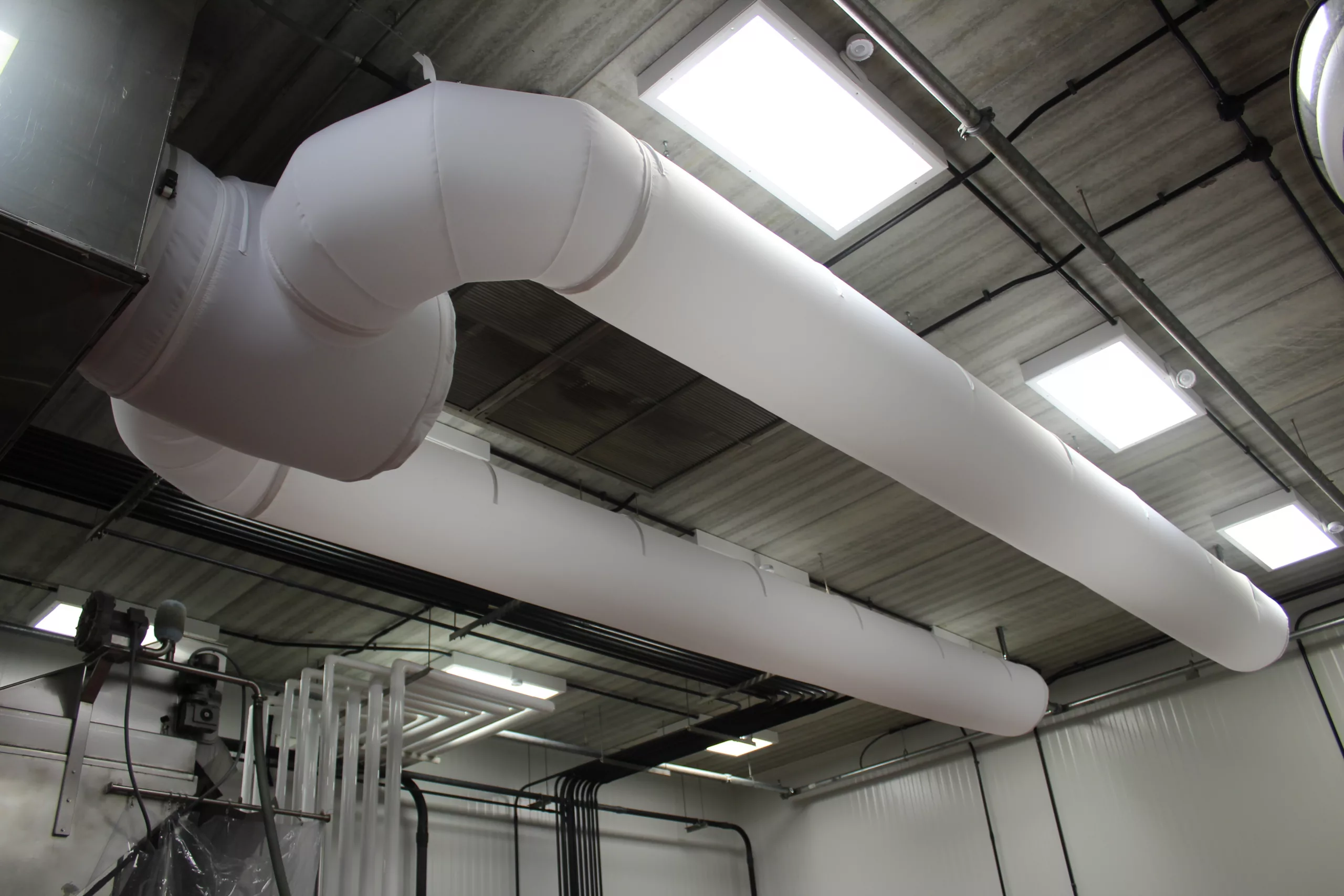 White industrial air ducting system inside a warehouse
