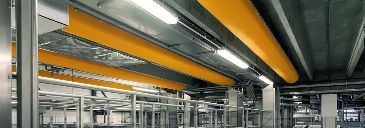 Yellow, industrial zip-a-duct ducts inside a factory