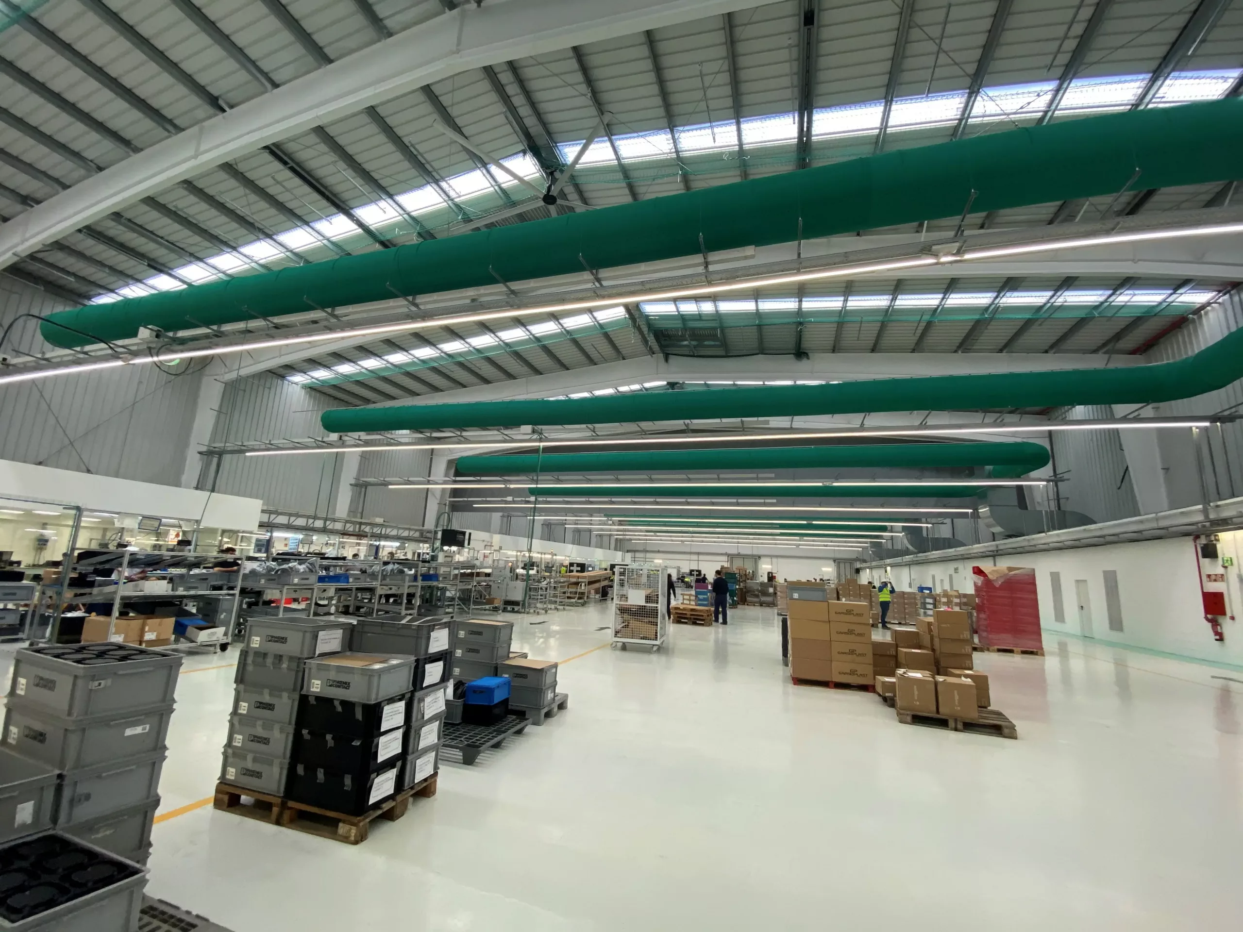 Green, industrial zip-a-duct ducts in Wallbox warehouse, ES